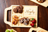 A custom charcuterie board with handle and family name engraving